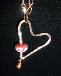 Hammered copper heart with fine silver and lampworked bead.